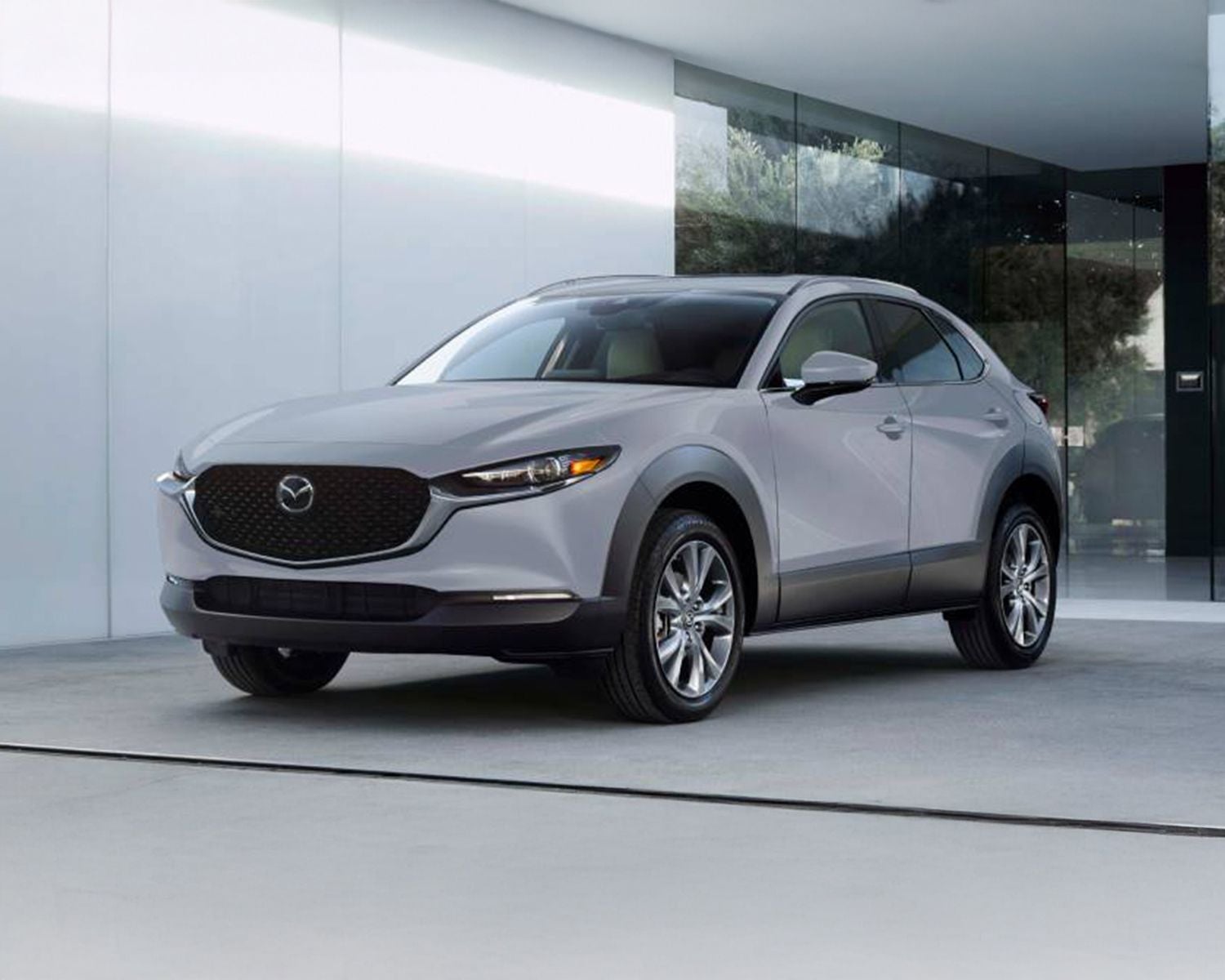 Front 3/4 shot of the 2025 Mazda CX-30 parked in front of modern home.