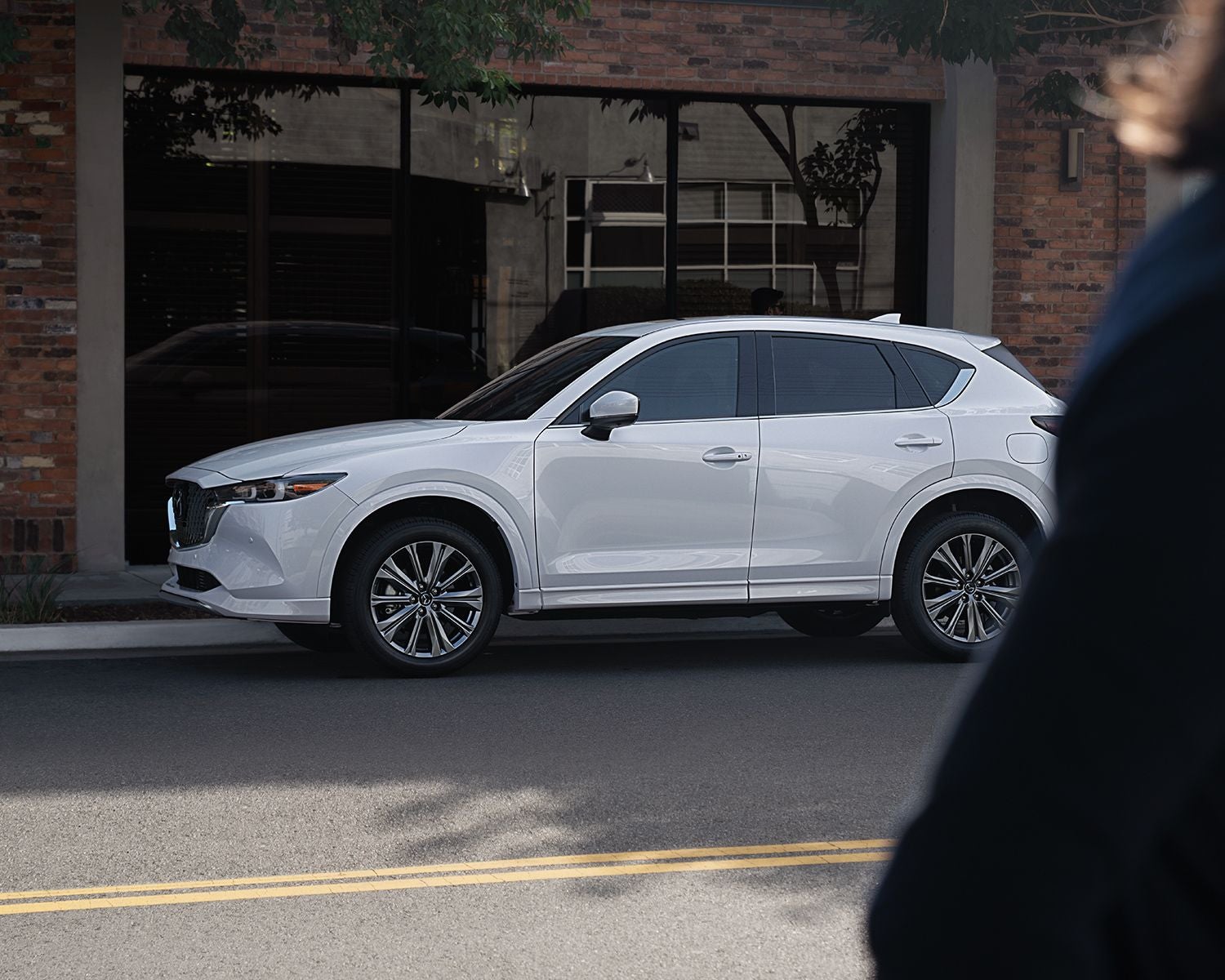 Side profile shot of the 2025 Mazda CX-5 parked on street.