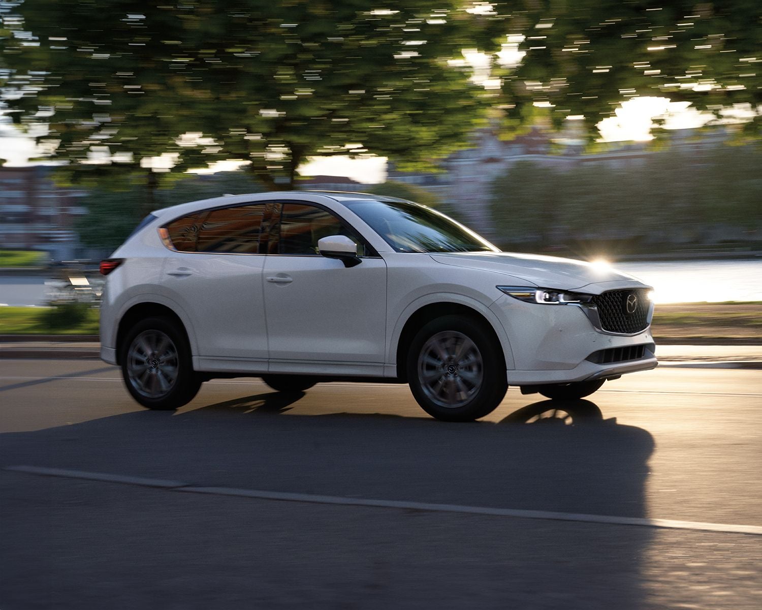 Side profile shot of the 2025 Mazda CX-5 driving down road.