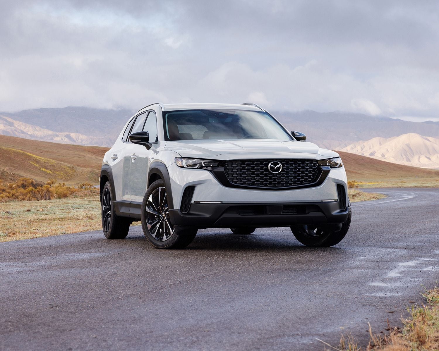 Front 3/4 shot of the 2025 Mazda CX-50 Hybrid parked on road.